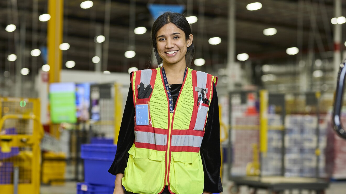 Area Manager Paaromita Chakravarty stands in fulfilment centre smiling