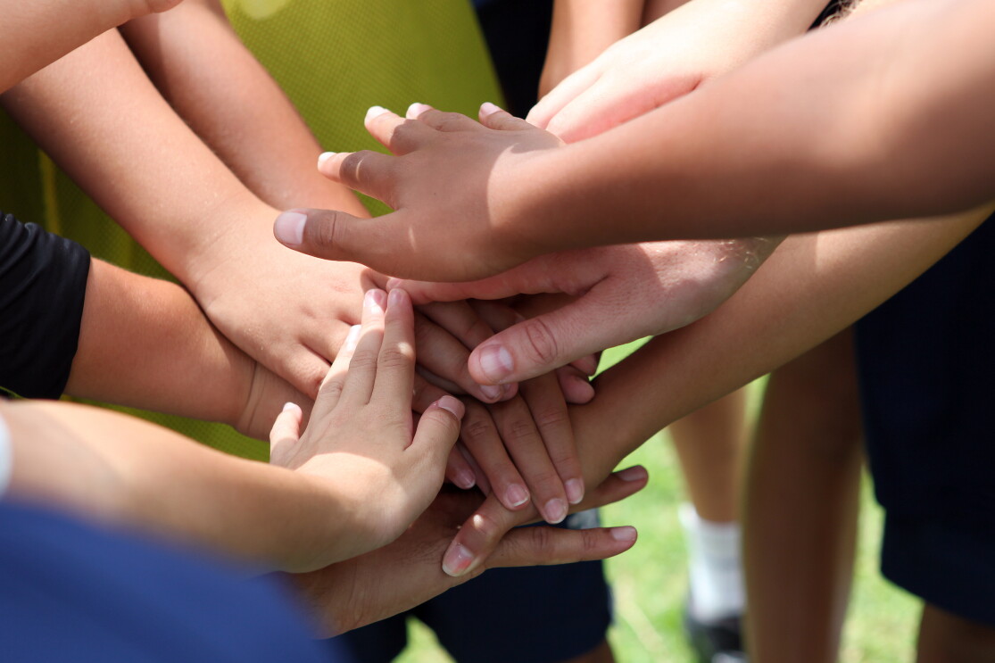 Multiple hands on one another to show unity