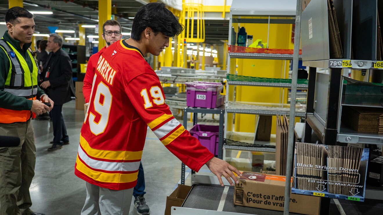 Two Calgary Flames hockey players packing and shipping Amazon boxes