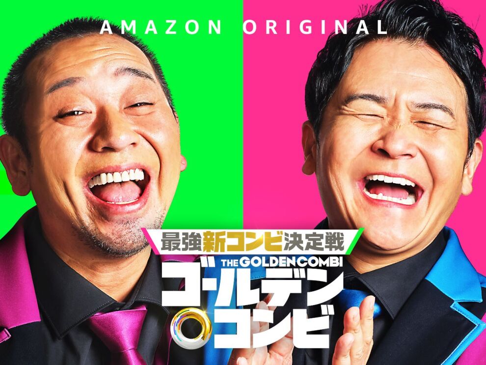 左側には、ピンクのネクタイを着ている男性が笑っている。右側には、青い襟のスーツを着ている男性が大笑いしている。