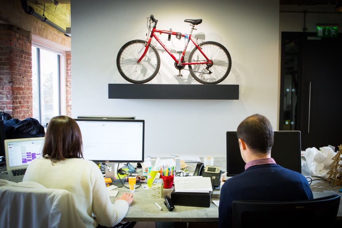 People sat at computers with a small bike in the foreground
