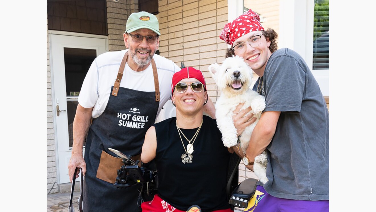 Ryan smiling and posing with his family and dog.