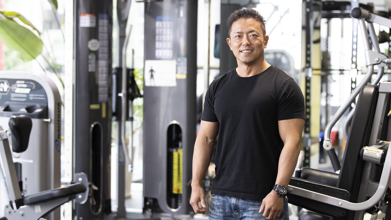 本格的なトレーニング器具がおかれたジムにて、笑顔の大谷さん