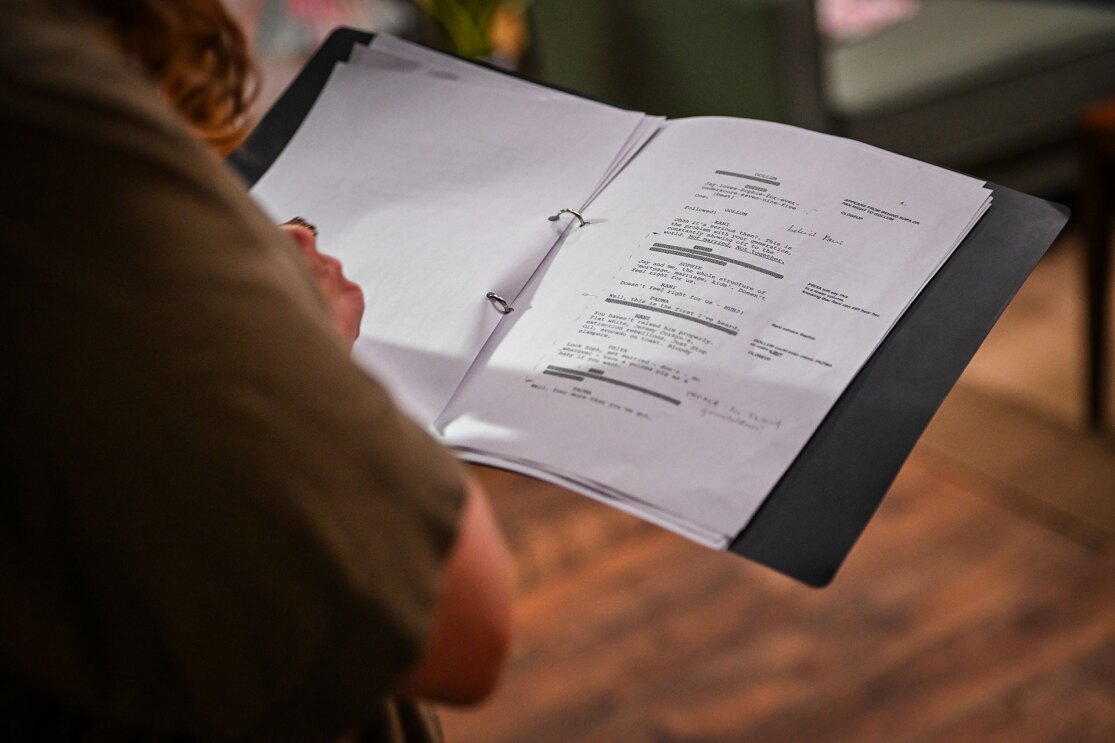Close-up of hands holding open folder with typed paperwork