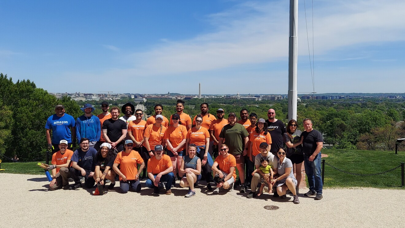 Diverse group poses on hilltop overlooking Washington DC skyline