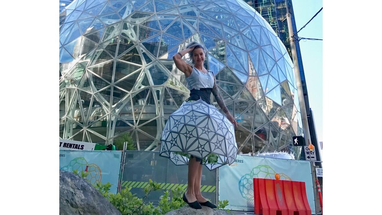 sheridan wearing a spherical dress and posing in front of the matching Amazon Spheres.