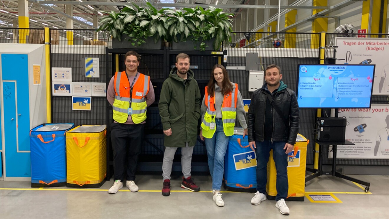 Gruppenfoto von Amazon Schichtleiterin Kseniya und ihren Kollegen aus dem Verteilzentrum Wien Simmering bei der Sammlung von Winterkleidung für geflüchtete Menschen aus der Ukraine.