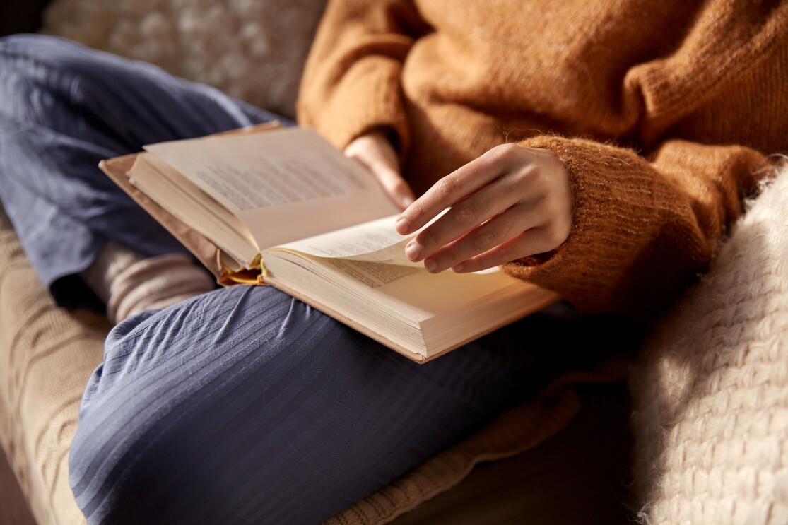 woman in warm sweater reading book at home_1