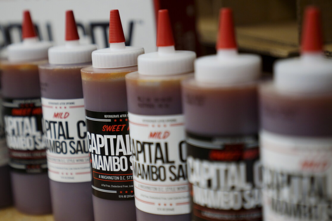 Bottles of both Capital City flavors, Mild and Sweet Hot, are lined up alternating in spots.