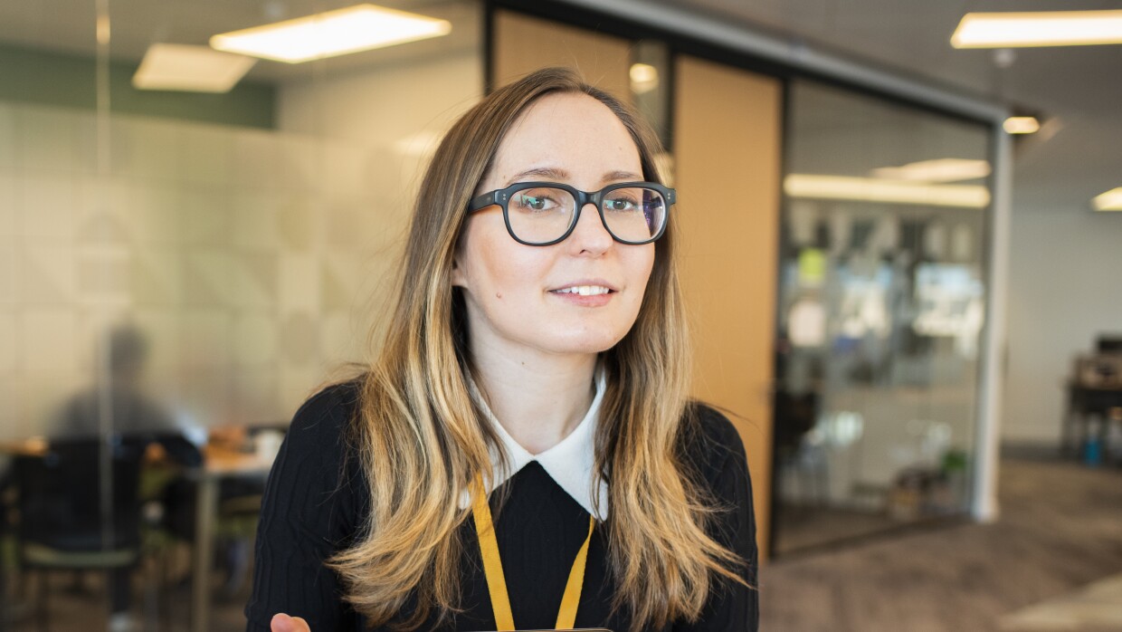 Female employee wearing glasses and sat in an Amazon office