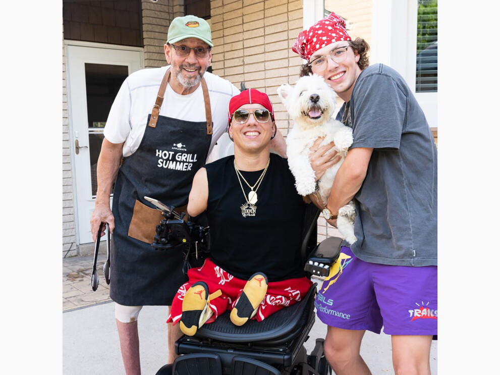 Ryan smiling and posing with his family and dog.