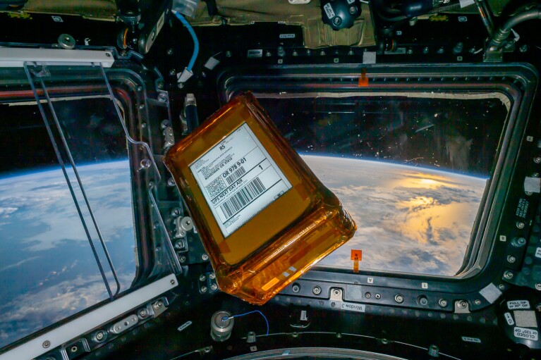 An image of the AWS Snowcone device floating in a space ship. There is earth in the view out the window in the background.