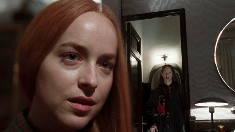 Woman with red hair in foreground, mirror reflection in background