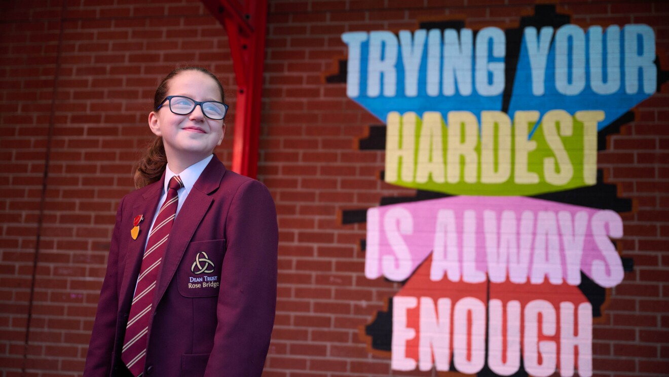 A student stands in front of a Will Poulter quote