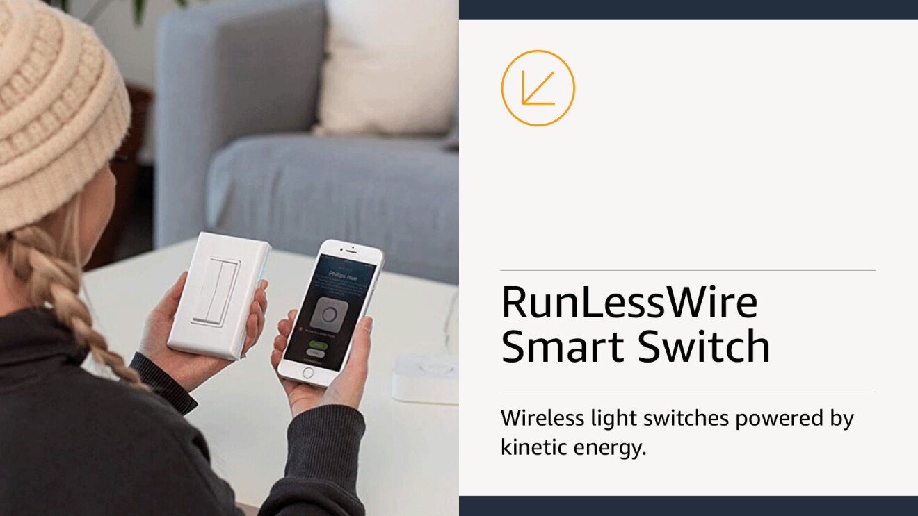Woman sitting in her living room holding her smartphone in her right hand and a wireless light switch in her left hand.