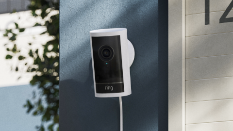 Smart home security device installed next to greenery and house number