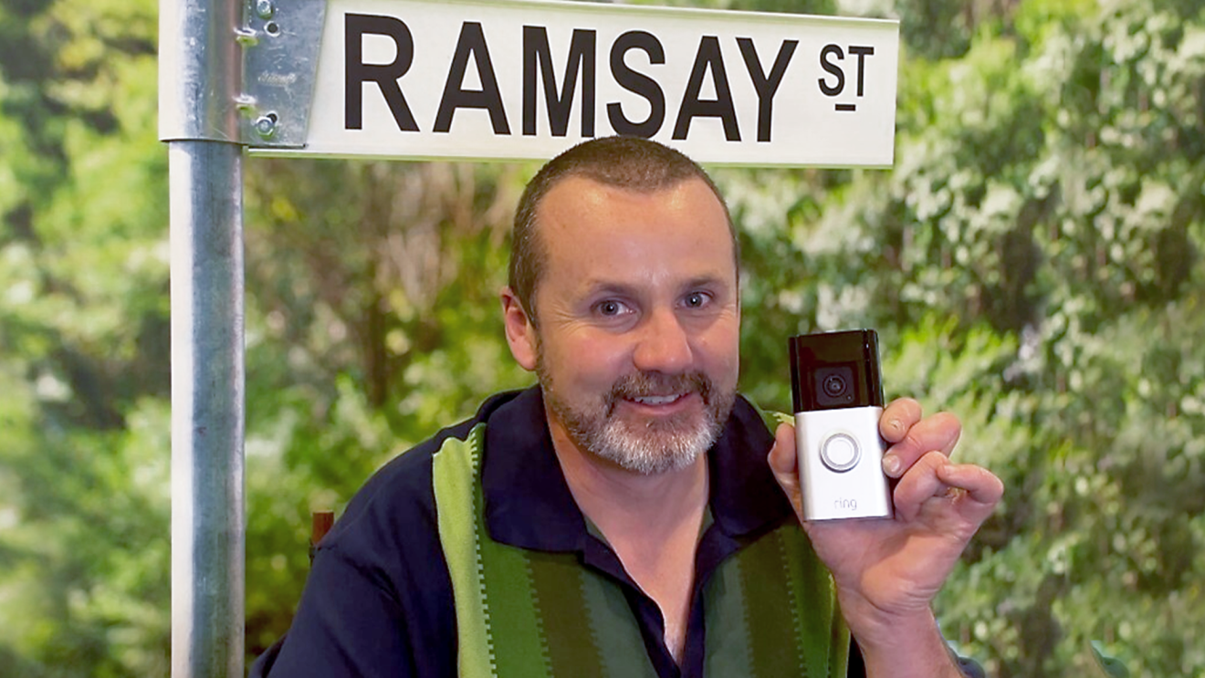 Ryan Moloney from Neigbours holding a Ring Video Doorbell. 