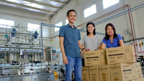 The team behind Happyganics, with their products in a factory
