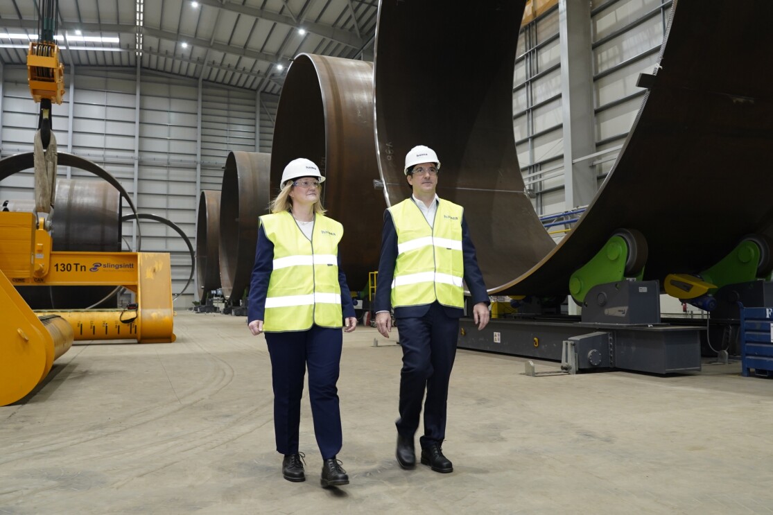 Man and women in hi vis jackets survey a warehouse site