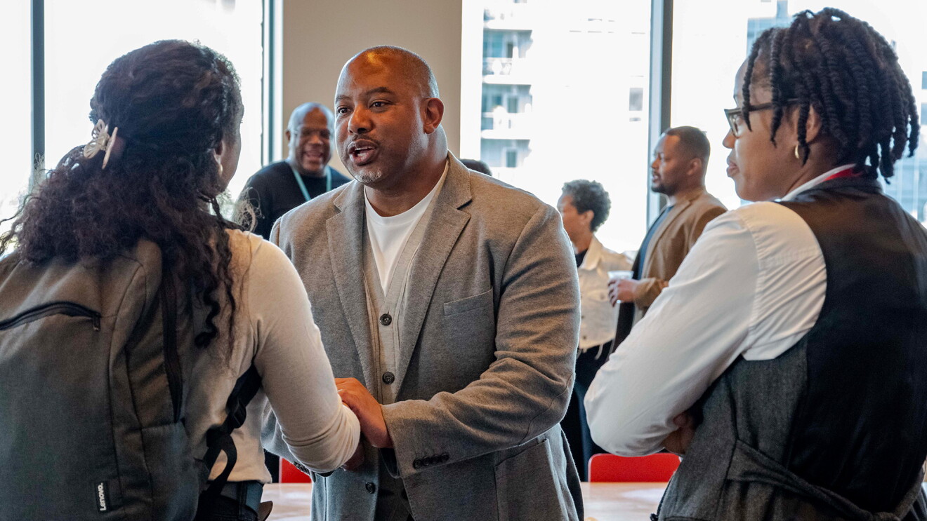 A photo of Daryl Hammett, general manager of global demand and operations at AWS, shaking hands with attendees at the ENABLE Summit.