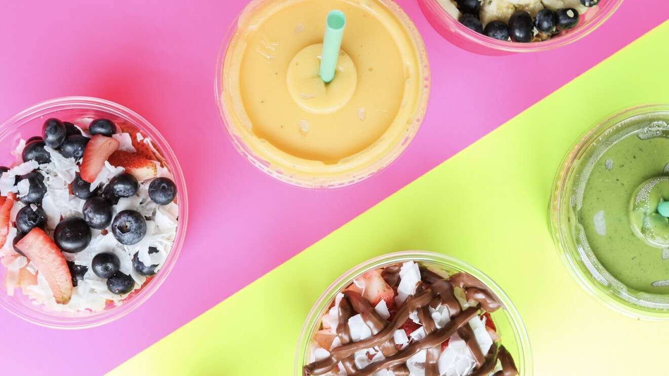 A photo of three açai bowls- and two smoothies.