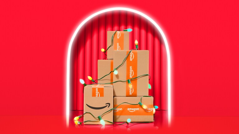 Illuminated arch framing Amazon boxes decorated with holiday lights