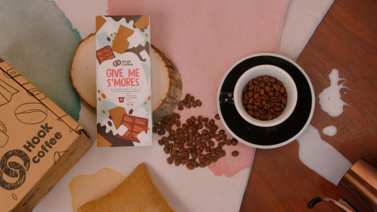 Give Me Smores placed beside a cup of coffee beans