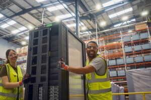 Two employees holding server racks in a data center.