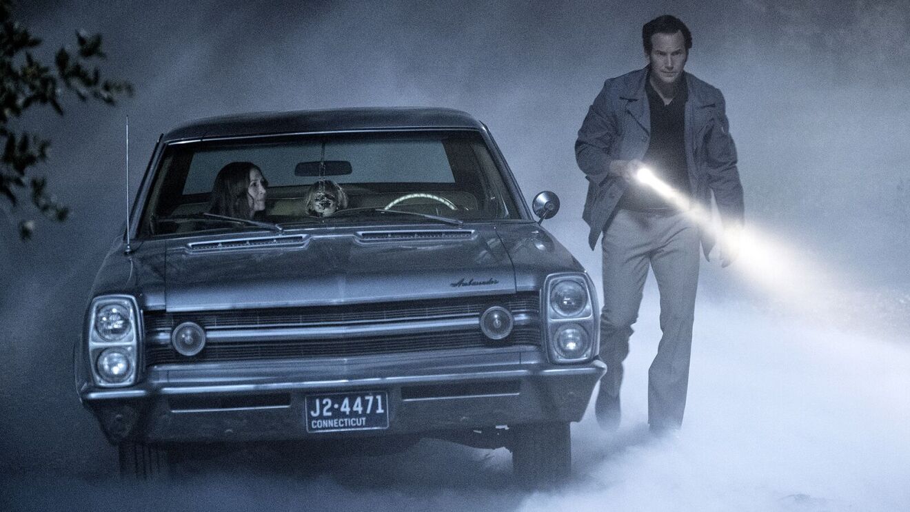 The Conjuring movie: Vintage car in foggy night, man with flashlight investigating