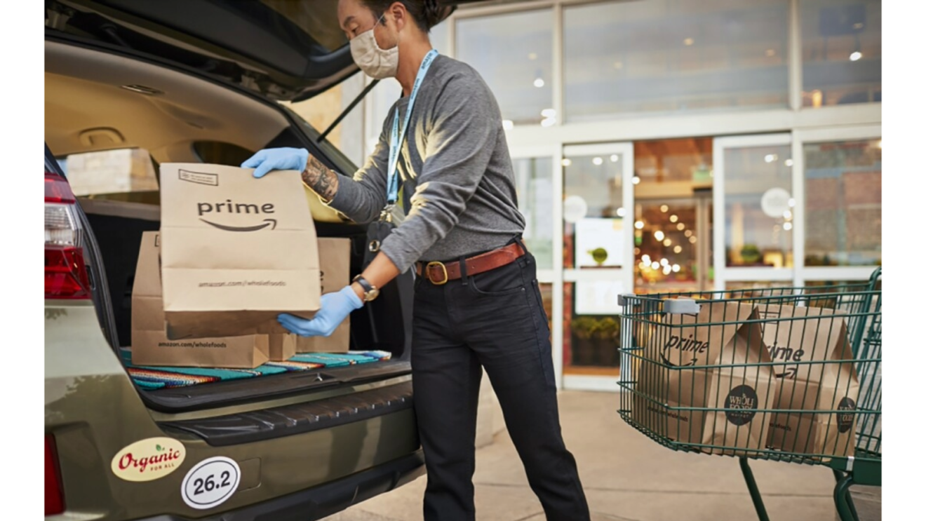 Amazon Prime delivery worker loading packages into car trunk