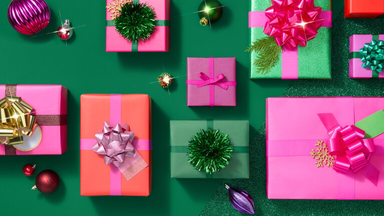 A selection of vibrantly wrapped Christmas presents on a deep green background