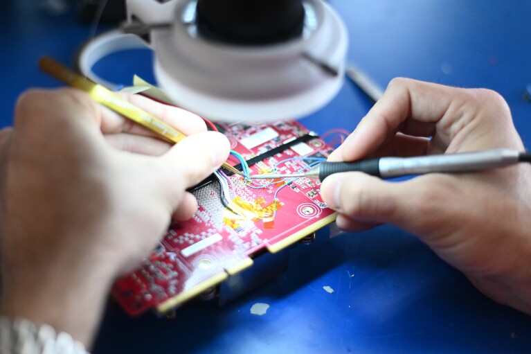 Close-up of engineer's hands working on computer chip