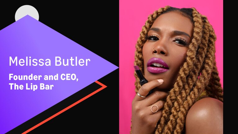 Founder and CEO of The Lip Bar posing against bright pink background