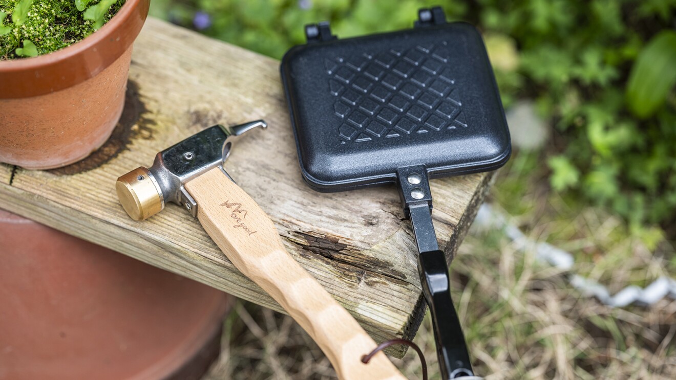 屋外にある棚の上に置かれたペグハンマーとホットサンドメーカー