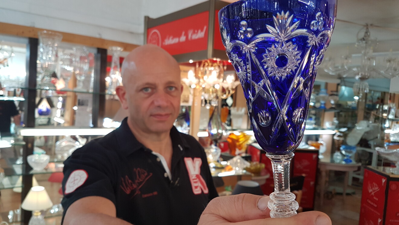 Valery Klein presenting crystal items he crafts 