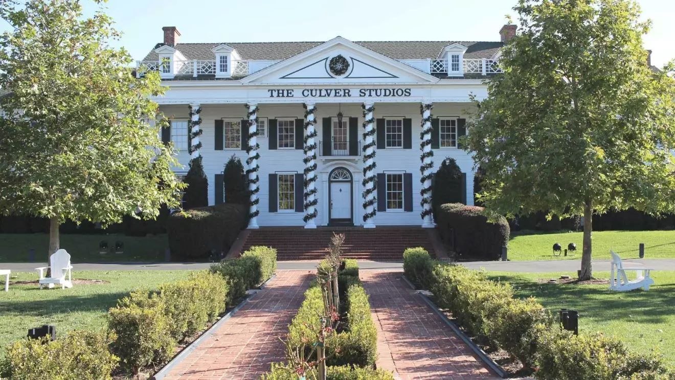 白い大邸宅の前に通り道と庭が広がっている。その大邸宅の屋根の下には「The Culver Studio」が書かれている。