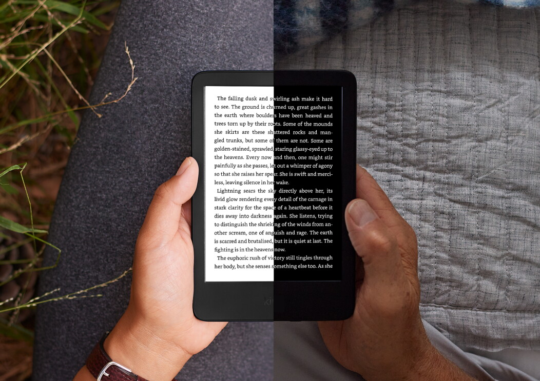 A pair of hands holding a Kindle, with one side in light mode and the other in dark mode