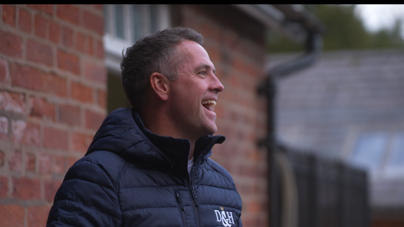 Michael Owen smiles while facing away from the camera 