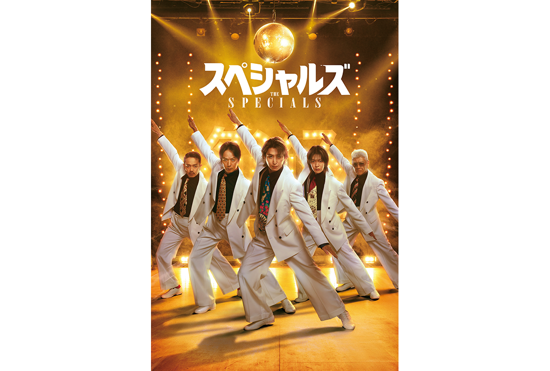 黄色い光に照らされたステージで、両腕を上下斜めに大きく広げて踊る5人の人物。全員白いスーツに黒いシャツを着用、派手なネクタイをしている。