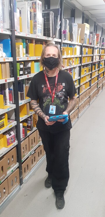 Graeme Ferry, Associate at Amazon's fulfilment centre in Peterborough, pictured standing in one of the aisles.