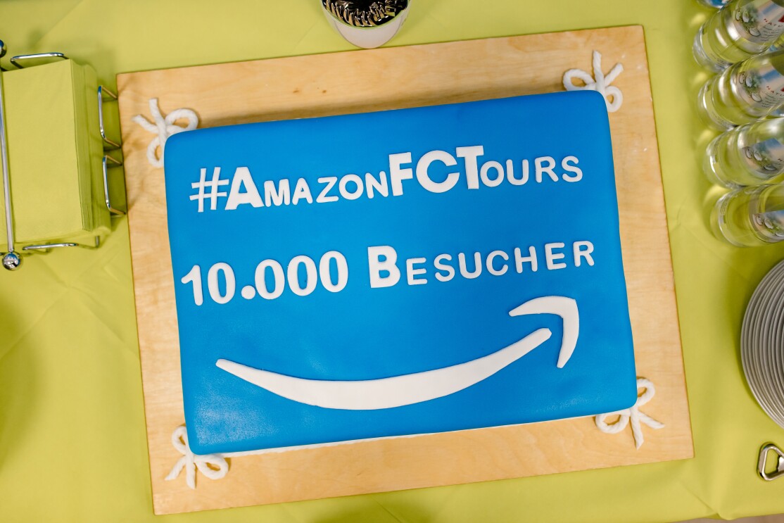 Eine blaue rechteckige Torte mit der Aufschrift #AmazonFC Tours, 10.000 Besucher