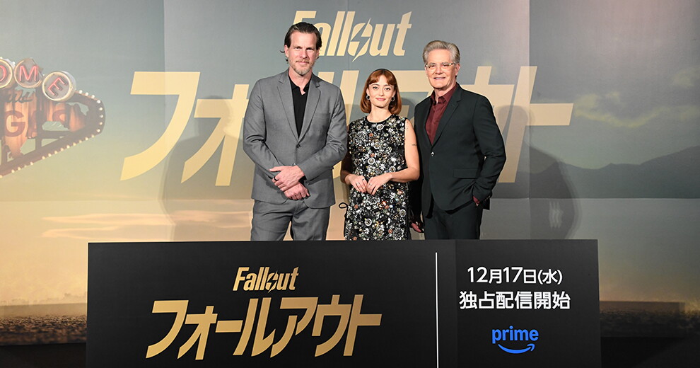 空と水面が描かれた壁を背に立つ3人の人物。脚の前に黒いパネルが置かれ、「フォールアウト 12月17日（水）独占配信開始」と書かれている。