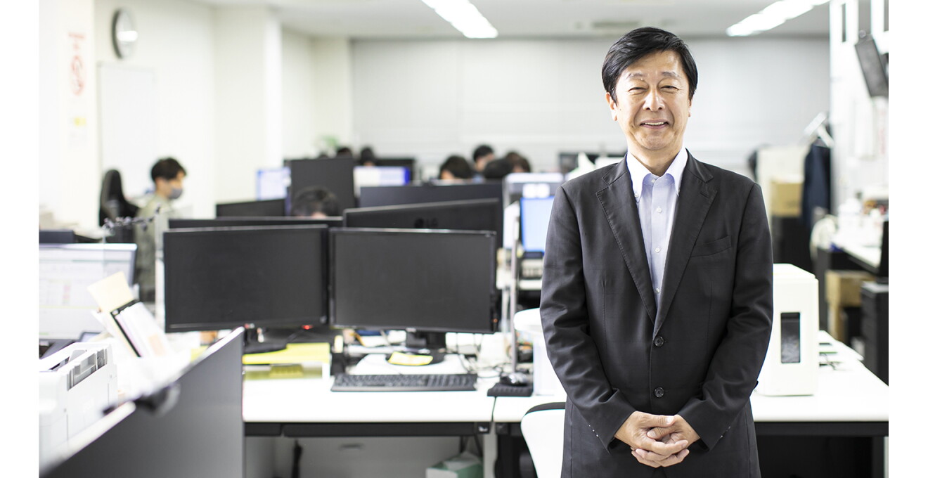 オフィスを背景にした吉田さんの写真