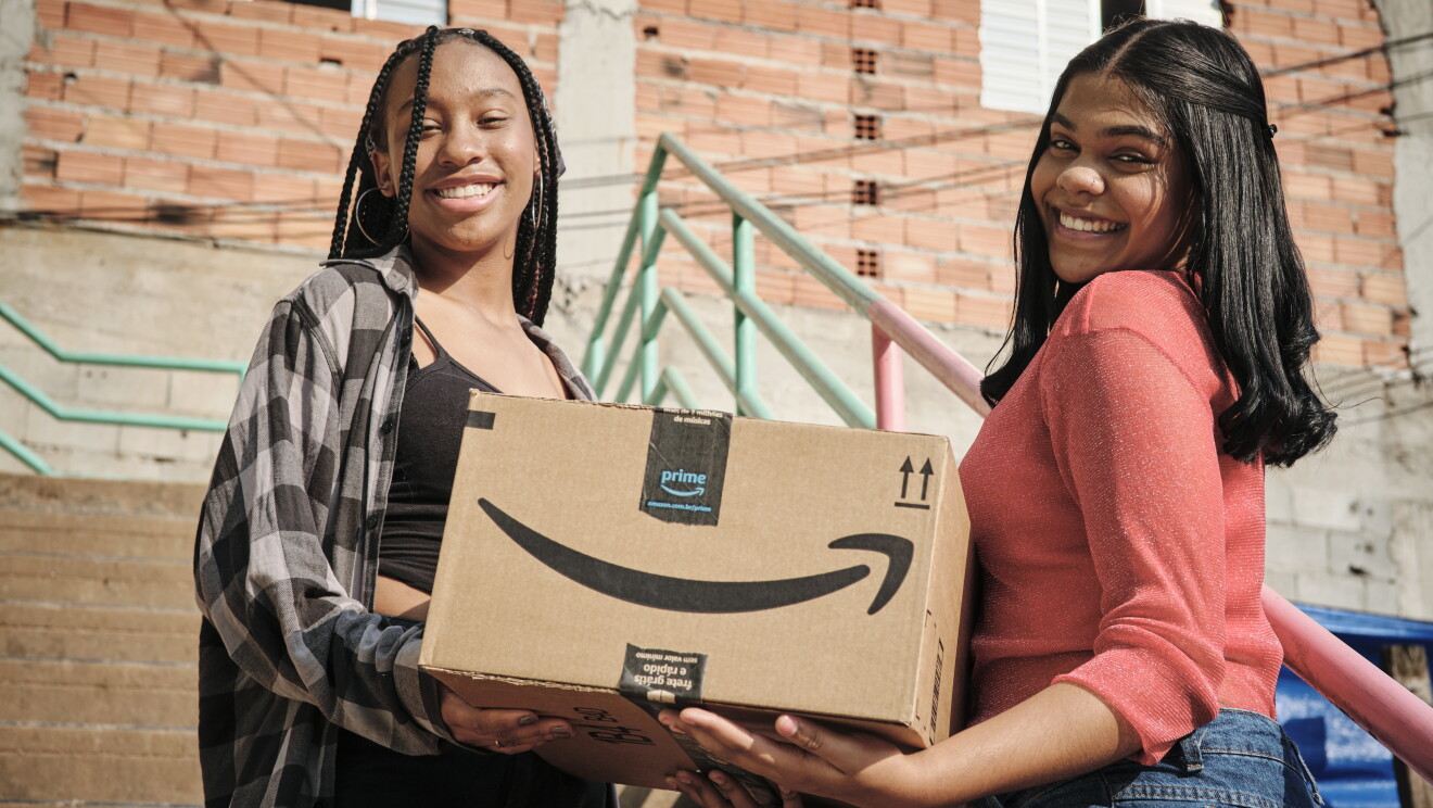 Mulheres seguram caixas da Amazon Prime em Paraisópolis