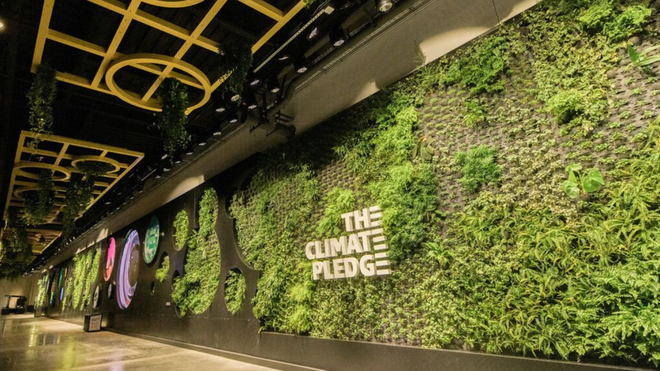 A green wall with Climate Pledge advertised 