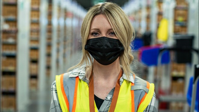 考特尼Smethers戴着口罩在亚马逊完成中心和一个黄色的背心。