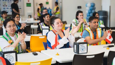 Amazon employees sitting at tables and clapping