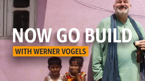 Werner Vogels, CTO of Amazon stands besides two young children in India