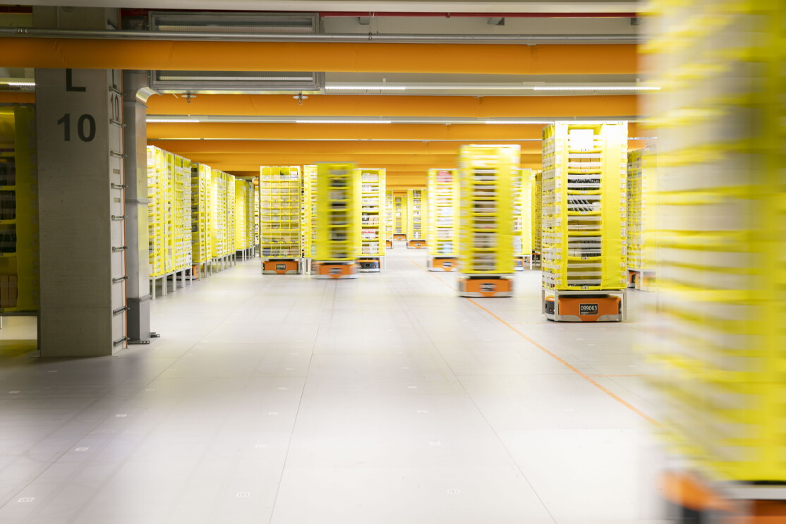 Schmale gelbe Regale werden von den Transportrobotern durch das Logistikzentrum transportiert.