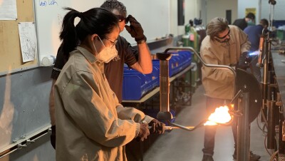 A student holds a blow torch in a lab. 